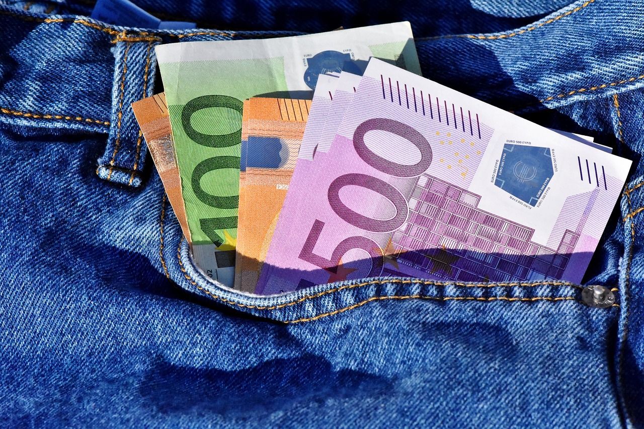 Farkkukankainen tasku, josta pursuaa euroseteleitä.