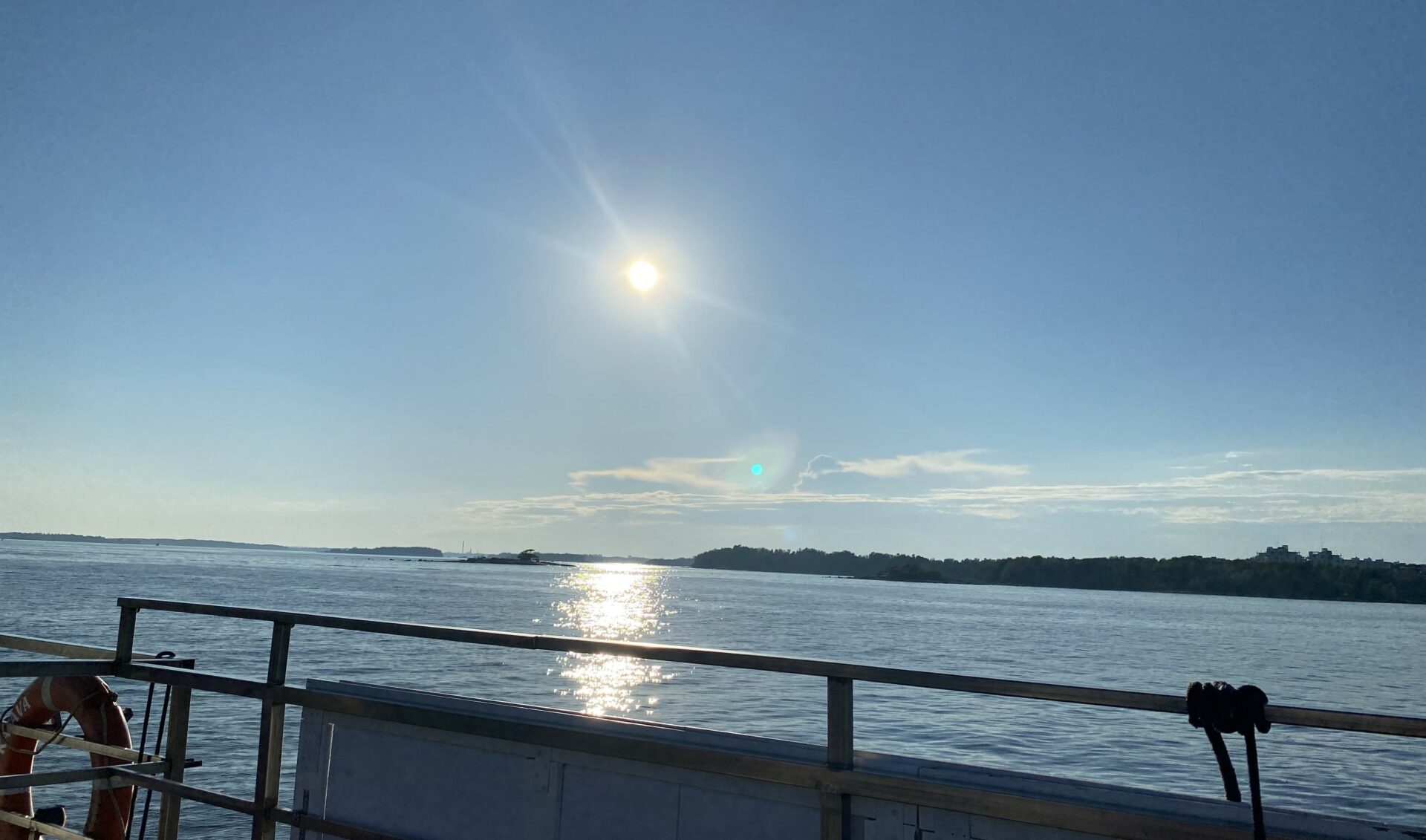 Aurinkoinen merimaisema laivankannelta kuvattuna. Vasemmalla on pelastusrengas.