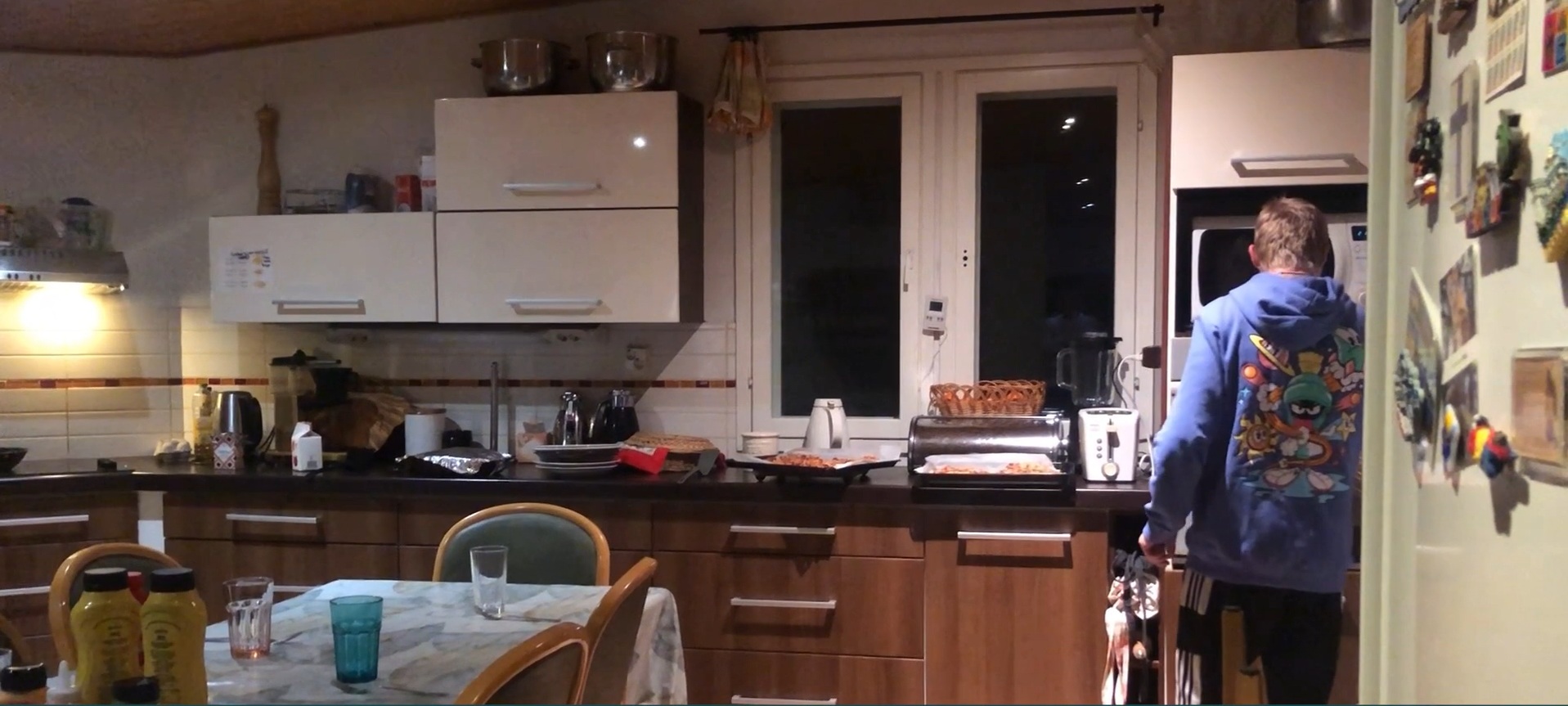 Keittiötila, jossa on keittiötaso, alakaappeja ja yläkaappeja. Oikealla seisoo selin mies.