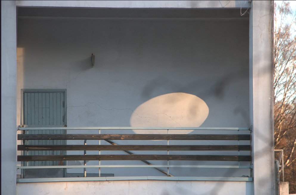 Kerrostalon parveke, jossa on ovi ja kaiteet.